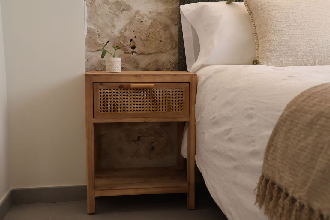 Detalle de lateral de cama y mesita de noche de madera