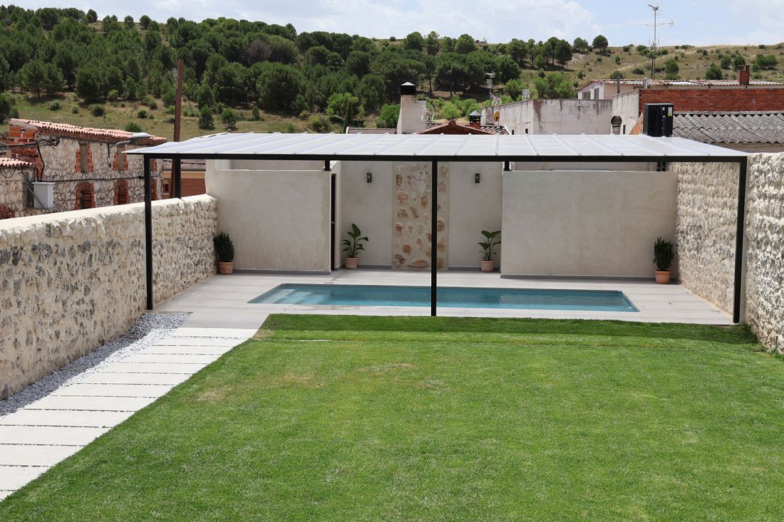 Vista del jardín exterior y piscina al fondo